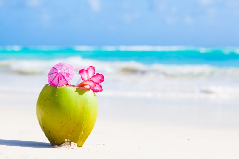 fresh coconut cocktail on tropical beach with flower