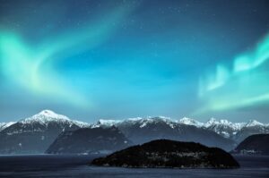 northern lights over snow mountains